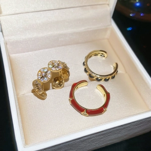 Macro shot of 14k gold plated open rings with red enamel and zircon details