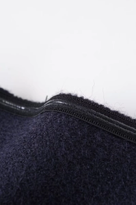 Macro shot of navy blue wool fabric texture with high-quality waterproof zipper detail