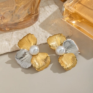 Detailed view of bicolor flower earrings with large pearls on a luxury background