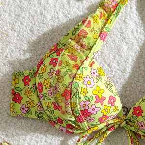 Détail du haut de bikini à fleurs vertes avec dentelle délicate et texture du tissu