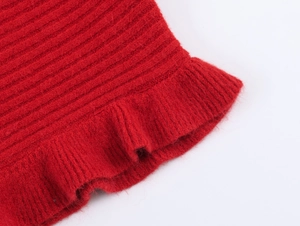 Close-up of red ribbed knit fabric featuring a wavy lettuce hem and ruffled edge detail
