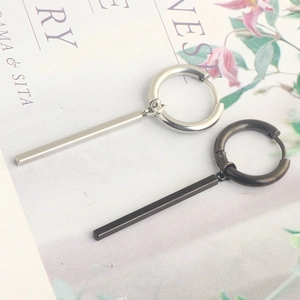 Detail of silver and black stainless steel hoop earrings with hanging pillar pendants