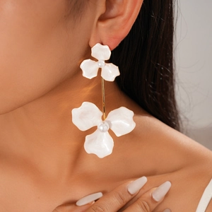 Close-up of bohemian white flower drop earrings with pearl center on model