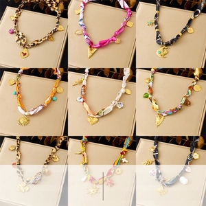 Detail of silk scarf necklaces with gold sun and heart pendants in various prints