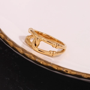 Detailed close-up of a 18K gold plated double-layer hollow wrap ring on a white plate