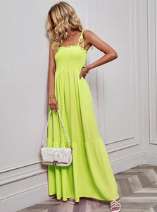 Detail of neon yellow strapless maxi dress featuring ruched chest and fluid fabric