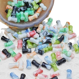 Perles en forme de bambou marbré de couleurs variées dans un bol en céramique pour DIY