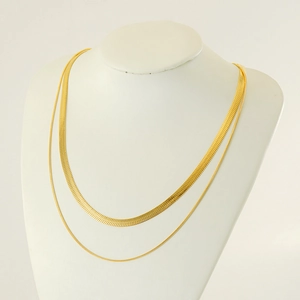 Gold double layered titanium steel flat snake chain necklace on a minimalist jewelry bust