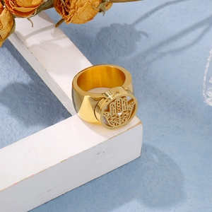 Close-up of golden wide ring with Hamsa Hand cutout and single rhinestone detail