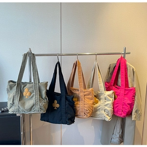 Detailed view of five color options for vintage canvas tote bags with club flower patches