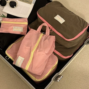Pink and brown waterproof nylon travel organizers packed inside a suitcase