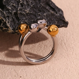 Detail of creative open ring with alternating silver and 18K gold beads on textured rock