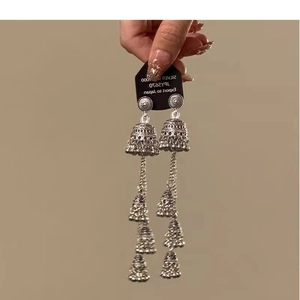 Detail of vintage bohemian silver tassel earrings featuring ornate tribal bell designs
