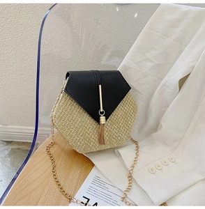 Detail of a hexagonal straw crossbody bag with black leather flap and gold chain strap