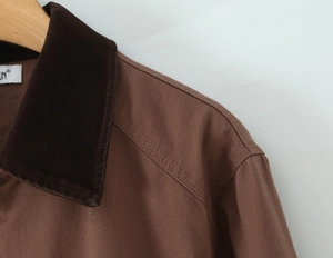 Detail of brown jacket with corduroy collar and reinforced stitching on shoulder