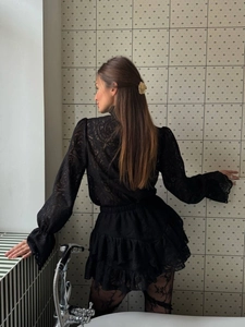 Detailed back view of black lace lantern sleeve top and ruffled tiered skirt outfit