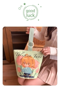 Detail of light green canvas tote bag featuring wooden ring handle and tulip illustration