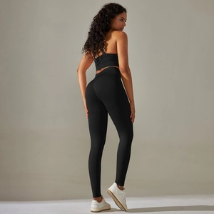 Detail of cross back straps on black seamless sports bra and high-waist yoga leggings