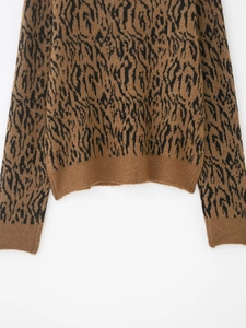 Close-up of brown and black tiger pattern knit sweater with ribbed cuffs and soft texture