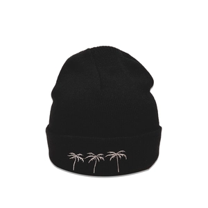 Close-up of three palm tree embroidery details on a black knitted winter beanie cap