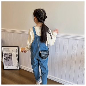 Detail of children's heart-shaped quilted crossbody bag with gold chain strap
