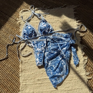 Détail de l'ensemble bikini 3 pièces à fleurs avec haut à nouer et paréo assorti