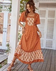 Close-up of bohemian floral print dress in orange and beige with square neckline detail