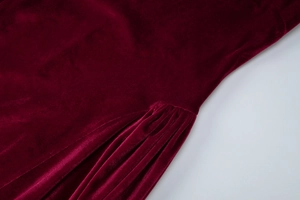 Detail of waist pleats on this burgundy velvet dress showing texture and luster