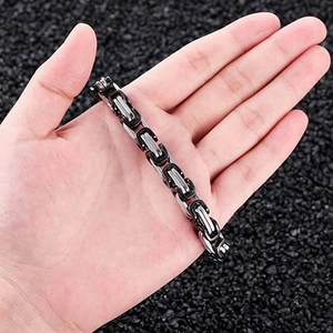 Close-up of black and silver stainless steel king chain bracelet worn on wrist