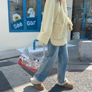Detail of light blue shoulder bag featuring cute cartoon dog prints and casual street style