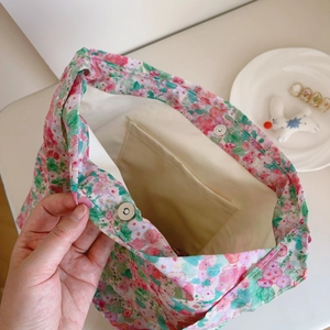 Detail view of pink floral cotton bag featuring inner pocket and magnetic metal clasp
