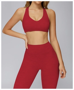 Close-up of red yoga set featuring V-neck sports bra and high-waist textured leggings