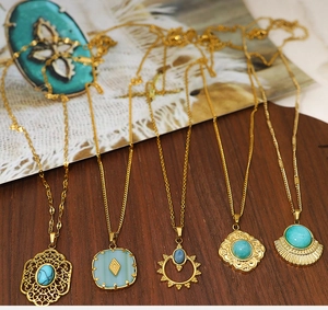 Macro shot of five vintage gold-plated necklaces with turquoise stones on wooden background