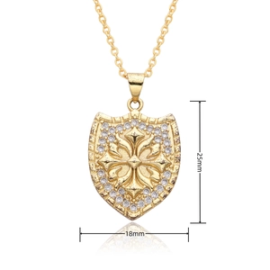 Detailed view of a gold shield pendant with a cross and white crystal, 25mm x 18mm size