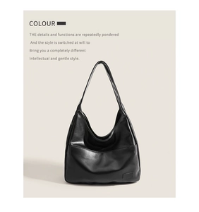 Detail of the high-quality black faux leather texture and minimalist shoulder strap design