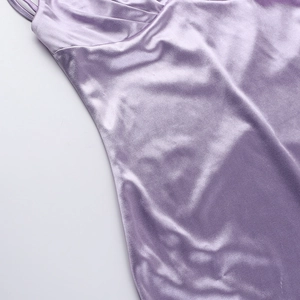 Detail of purple satin dress featuring elegant pleats and high-shine silk-like texture