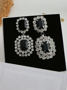 Dettaglio di orecchini vintage quadrati con gemme nere e bordi di strass lucidi