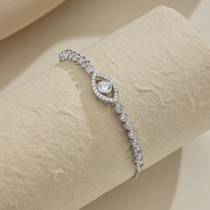 Detail of silver clover tennis bracelet with evil eye pendant and sparkling cubic zirconia