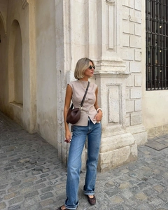 Look street style con gilet a quadretti beige abbinato a jeans blu a gamba dritta
