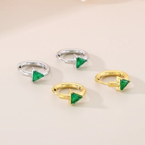Detail of 18K gold and silver plated earrings featuring triangular green crystal stones