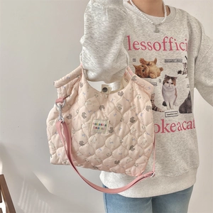 Detailed view of pink quilted crossbody bag with cute animal prints and brand label