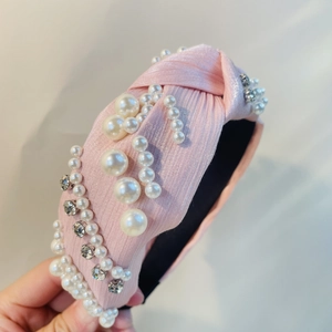 Detail des rosa geknoteten Haarreifs mit eleganten Perlen und Strasssteinen