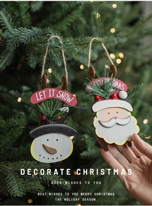 Close-up of wooden Let It Snow ornament on Christmas tree with bokeh lights