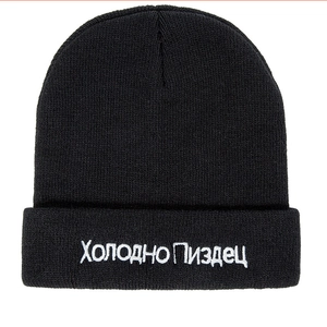 Black knit beanie with white Russian embroidery and classic cuffed design for winter