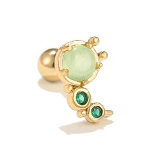 Detail of gold piercing stud with green cat eye stone and cubic zirconia floral arrangement