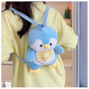 Rear view of a cute blue plush penguin backpack with adjustable straps worn by a model
