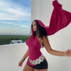 Détail d'un top fuchsia à une épaule avec capuche, rubans asymétriques et ceinture en métal