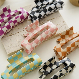 Set of six checkered acetate hair claws in various vibrant colors on stone surface