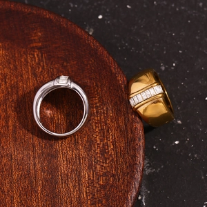 Close-up of gold and silver thick rings with rectangular baguette-cut clear stones