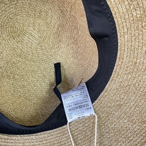 Internal detail of a women's straw sun hat showing adjustable strap and paper blend texture